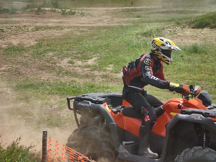 Гонщик на квадроцикле CFMOTO в облаке пыли